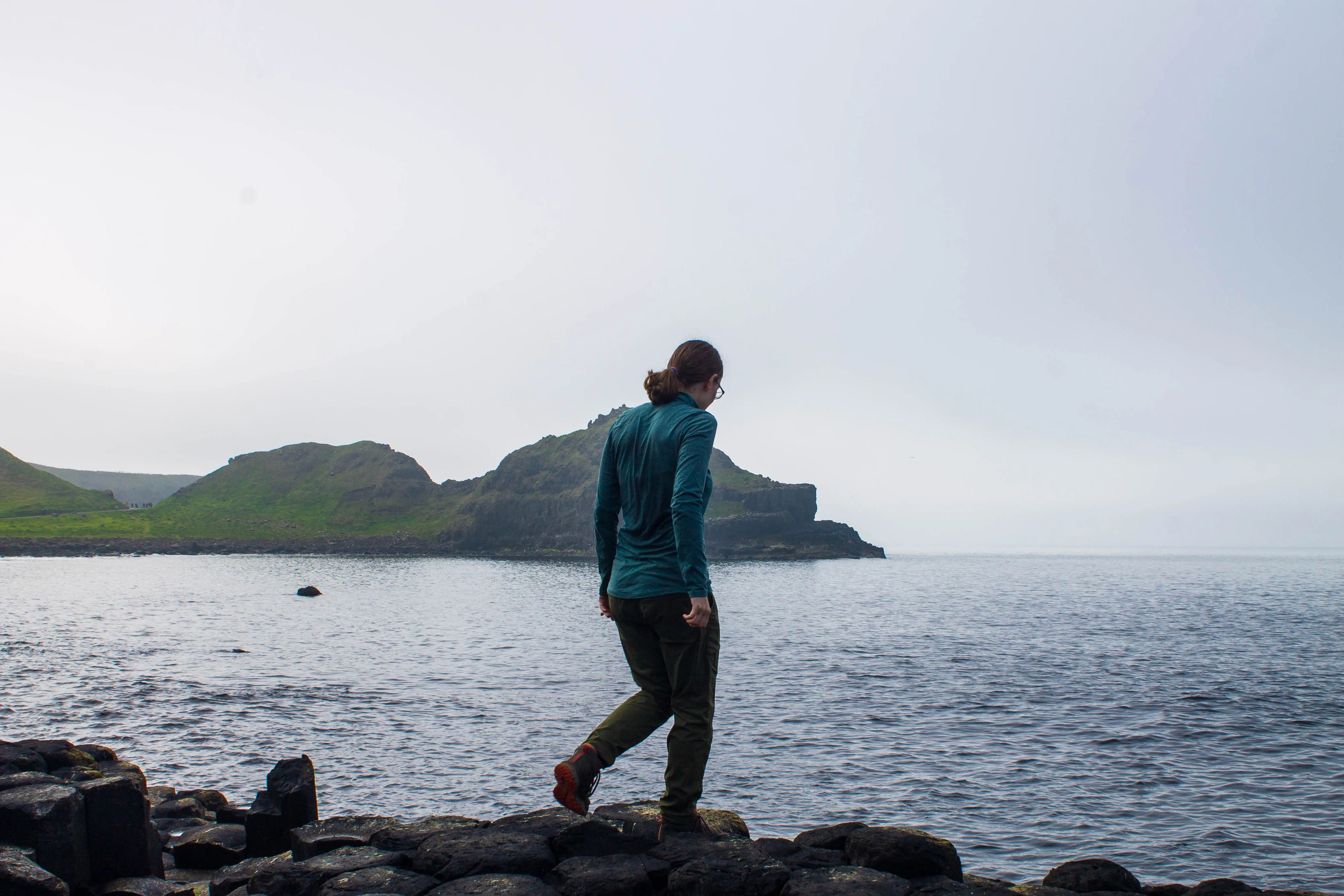 A woman walking across the Giant&#x27;s Causeway